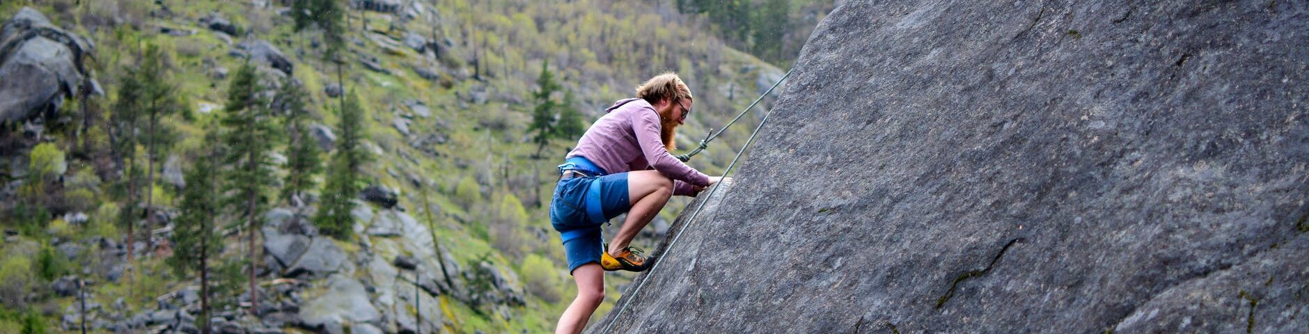 man climbing on rock mountain