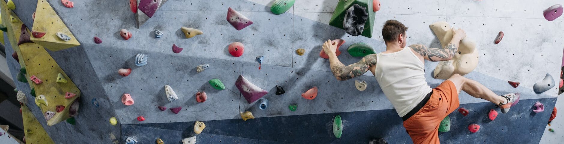 a person in activewear climbing a climbing wall