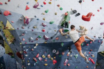 a person in activewear climbing a climbing wall